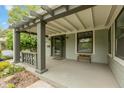 Cozy front porch featuring a gray pergola, balustrade, window bench, and ample natural light at 3614 Guilford Ave, Indianapolis, IN 46205