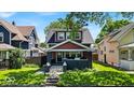 Inviting two-story home with a covered porch and a well-maintained front yard at 405 N Drexel Ave, Indianapolis, IN 46201