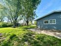 A spacious backyard with a large tree, green grass, and a glimpse of the side of the house at 503 Elmhurst Pl, Whiteland, IN 46184