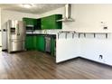 Updated kitchen with stainless steel appliances, granite countertops, green cabinetry, and stylish hardwood floors at 503 Elmhurst Pl, Whiteland, IN 46184