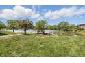 Scenic view of a backyard with lush green grass, trees, and a serene lake, ideal for outdoor enjoyment at 5038 Allisonville Rd # E, Indianapolis, IN 46205