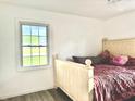 Bright bedroom with a window, a wooden bed frame, and neutral decor, offering a relaxing and comfortable space at 5200 N Leslie Dr, Muncie, IN 47304