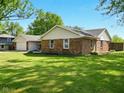 A well-kept single-story home featuring a brick exterior and a lush green lawn at 5200 N Leslie Dr, Muncie, IN 47304