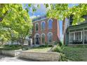 Charming brick home with arched windows and a blue accent trim, framed by a lush green tree at 543 Fletcher Ave, Indianapolis, IN 46203