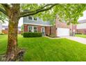 Two-story home with brick and siding, features a two car garage and manicured lawn at 5522 Grassy Bank Dr, Indianapolis, IN 46237