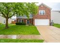 Two-story home with brick and siding, features a two car garage and manicured lawn at 5522 Grassy Bank Dr, Indianapolis, IN 46237