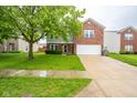 Two-story home with brick and siding, features a two car garage and manicured lawn at 5522 Grassy Bank Dr, Indianapolis, IN 46237