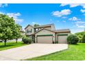 Charming two-story home with a three-car garage, well-manicured lawn, and mature trees at 5523 Gainesway Dr, Greenwood, IN 46142