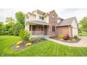 Inviting home with a charming front porch, landscaped garden beds, and a well-manicured lawn at 6039 Chinkapin Dr, Columbus, IN 47201