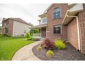 Beautifully landscaped front yard featuring lush greenery and a curved walkway leading to the home's entrance at 6039 Chinkapin Dr, Columbus, IN 47201