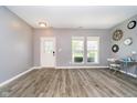 Bright living room with gray walls, wood floors, stylish light fixtures, and large windows at 6212 N Woods Edge Dr, McCordsville, IN 46055
