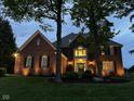 Elegant brick home at twilight, showcasing warm exterior lighting at 7248 River Birch Ln, Indianapolis, IN 46236