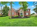 Lovely brick house with a vibrant green lawn and neatly trimmed bushes at 7248 River Birch Ln, Indianapolis, IN 46236