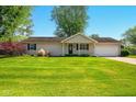 Attractive single-story home featuring a manicured lawn and inviting front entrance with black door and shutters at 813 Stoner Dr, Anderson, IN 46013