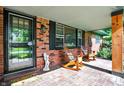 Cozy brick porch with rocking chairs, a glass storm door, and neutral brick flooring at 8230 Linda Leigh Ln, Indianapolis, IN 46217