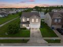 Inviting two-story home with attached two-car garage, water view, and manicured lawn at 8238 Crackling Ln, Indianapolis, IN 46259
