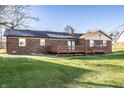 Back exterior of brick home with a spacious wooden deck and a well maintained lawn at 8510 E Mcgregor Rd, Indianapolis, IN 46259