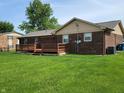 Backyard view of brick home with wood deck, lawn, and mature landscaping at 8510 E Mcgregor Rd, Indianapolis, IN 46259
