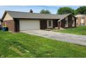 Brick ranch-style house featuring an attached two-car garage and a spacious driveway at 8510 E Mcgregor Rd, Indianapolis, IN 46259