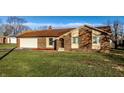 Charming brick home featuring an attached garage and well-maintained front lawn at 8510 E Mcgregor Rd, Indianapolis, IN 46259