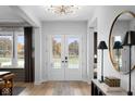 Bright foyer with hardwood floors, statement light fixture, and grand front doors with views at 9602 Fall Creek Rd, Indianapolis, IN 46256