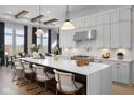Spacious kitchen with white cabinets, large island, stainless steel appliances, and stylish pendant lights at 9602 Fall Creek Rd, Indianapolis, IN 46256