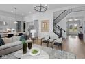 Open-concept living area with modern decor, fireplace, staircase, and abundant natural light at 9602 Fall Creek Rd, Indianapolis, IN 46256