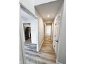 Bright hallway with new hardwood floors and fresh white walls leading to various rooms at 9655 Cedar Cove Ln, Indianapolis, IN 46250