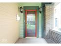 Close-up of front door with vintage sconces and brick detailing at 989 Woodruff Pl E Dr, Indianapolis, IN 46201