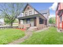 Inviting two-story home with a covered front porch and well-maintained lawn at 989 Woodruff Pl E Dr, Indianapolis, IN 46201