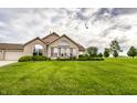 Beautiful brick home on a lush green lawn, complete with an attached garage and picture windows at 11646 Winding Wood Dr, Indianapolis, IN 46235