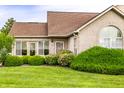 Attractive brick home featuring an arched window and complemented by lush green landscaping at 11646 Winding Wood Dr, Indianapolis, IN 46235