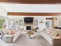 Open living room featuring a stone fireplace, comfortable sofas, and natural light creates a cozy atmosphere at 12 Windridge St, Country Club Heights, IN 46011
