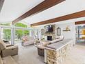 Bright living room with exposed beams, stone fireplace, and large windows offers a comfortable gathering space at 12 Windridge St, Country Club Heights, IN 46011