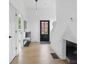 Bright foyer with hardwood floors, coat rack, and black front door, leading to a cozy interior at 1231 Marlowe Ave, Indianapolis, IN 46202