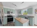 Charming kitchen featuring sage cabinets, stainless steel appliances, subway tile backsplash, and a butcher block island at 12422 River Valley Dr, Fishers, IN 46037