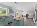 Open kitchen with sage cabinets, stainless steel appliances, wood-look flooring, and easy access to the backyard at 12422 River Valley Dr, Fishers, IN 46037