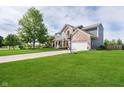 Beautifully maintained two-story home with lush lawn, basketball hoop, and attached two-car garage at 14130 Autumn Woods Dr, Carmel, IN 46074