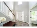 Welcoming foyer with hardwood floors, staircase, and ample natural light from a large window at 14130 Autumn Woods Dr, Carmel, IN 46074