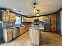 Well-lit kitchen features wood cabinets, stainless steel appliances, and a granite island at 1570 S Harriet St, Martinsville, IN 46151