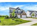 Charming two-story home with brick and siding, a well-kept lawn, and an attached two-car garage at 15717 Hush Hickory, Westfield, IN 46074