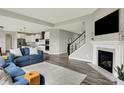 Cozy living room featuring a fireplace, comfortable blue sofa, and an open view to the modern kitchen at 15717 Hush Hickory, Westfield, IN 46074