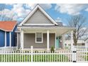 Charming gray home with white picket fence and inviting front porch in a quaint neighborhood setting at 1804 Spann Ave, Indianapolis, IN 46203