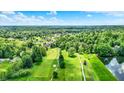 Expansive aerial shot showcasing the golf course, pond, and surrounding wooded landscape at 1860 Red Fox E Ct, Martinsville, IN 46151
