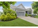 Charming home featuring a gray two-car garage, blue siding, and a well-manicured green lawn at 18630 Goldwater Rd, Westfield, IN 46062