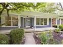 Inviting covered front porch with blue siding, white trim, ample windows, and lush landscaping at 19446 Ethan Allen Ln, Westfield, IN 46074