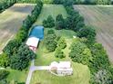Expansive property featuring a brick home with metal roof, a pond, a barn, and surrounding fields and trees at 19702 Centennial Rd, Sheridan, IN 46069