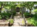 Charming home's front entrance with stone steps and lush landscaping, framed by mature trees at 2134 N Alabama St, Indianapolis, IN 46202