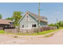 View of the charming home with light blue siding, white trim and fenced yard on a corner lot at 2230 Pleasant St, Indianapolis, IN 46203