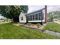 Landscaped front yard and exterior view showing the home's screened in porch and brick chimney at 3324 S Walnut St, Muncie, IN 47302